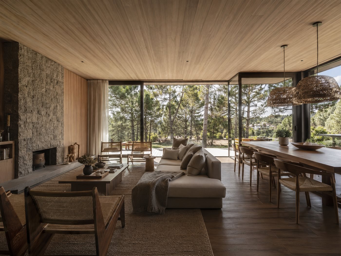 Arquitectura residencial contemporánea en Pinamar: carpinterías negras, cielorraso de madera, chimenea de piedra y bosque de pinos
